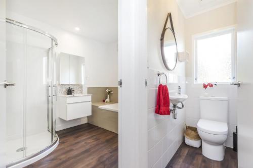 bagno con servizi igienici, lavandino e specchio di Whitby sea view a Porirua