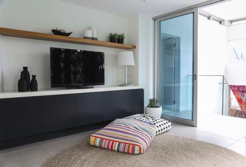 sala de estar con TV y reposapiés en Hastings Park: Luxury Penthouse, Private Pool & Views, en Noosa Heads