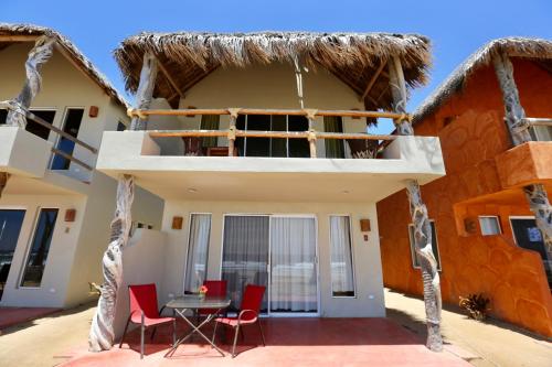 a patio of a house with red chairs and a table at Cerritos Surf Town - Beach Front Property in El Pescadero