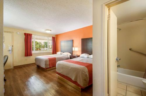a hotel room with two beds and a bath tub at Motel 6-Washington, DC - Convention Center in Washington