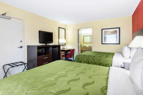 a hotel room with two beds and a flat screen tv at Quality Inn & Suites Lexington in Lexington