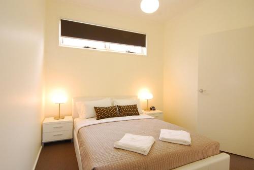 a bedroom with a bed with two white towels on it at Skyline- Best Executive Bendigo CBD Accommodation 2020-21 in Bendigo