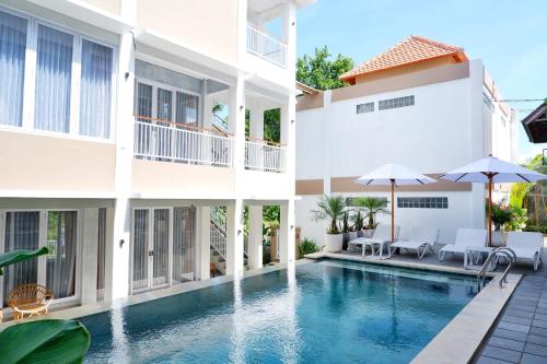 a villa with a swimming pool and a building at The Sloth Bali in Canggu