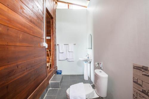 Un baño blanco con inodoro y lavabo. en Tanah Penida Bungalows, en Nusa Penida