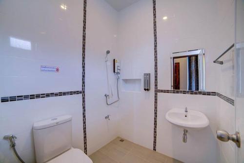 a white bathroom with a toilet and a sink at The Sleep Resort in Chiang Mai