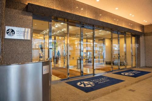 a lobby of a building with glass doors at Miyako Hotel Amagasaki in Amagasaki
