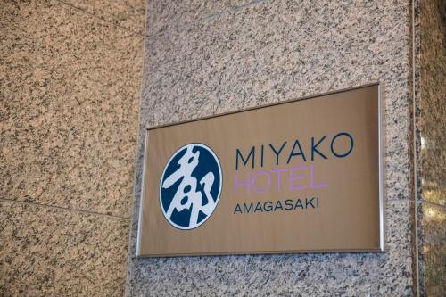 een bord voor mykonos hotel op een gebouw bij Miyako Hotel Amagasaki in Amagasaki