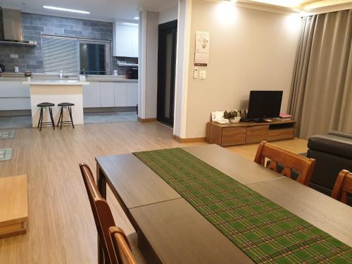 un soggiorno con tavolo da pranzo e cucina di Grace River House-Block B a Hoengseong
