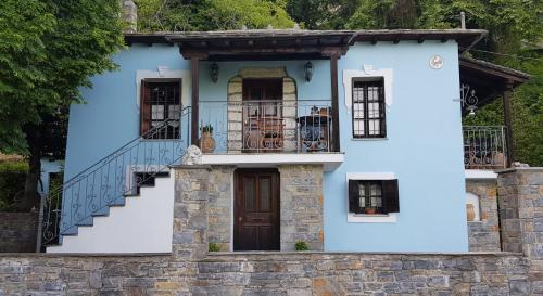 a blue house with stairs and a balcony at Tsagarada Stone House 1898 in Tsagarada