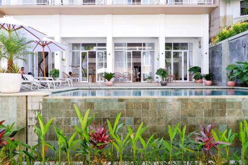 una piscina frente a una casa con plantas en The Sloth Bali, en Canggu
