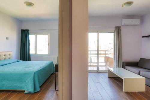 un dormitorio con una cama y un sofá en Vega Apartments, en Limassol