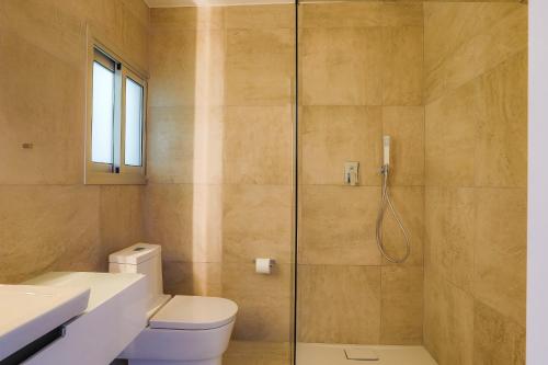 Un baño con inodoro y ducha de cristal. en Vega Apartments, en Limassol