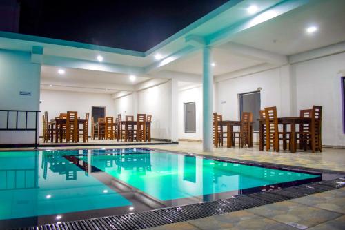 a swimming pool in a building with chairs at Lion Resort in Polonnaruwa