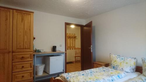 a bedroom with a bed and a dresser in it at Hotel Garni Forsthaus Ruhpolding in Ruhpolding