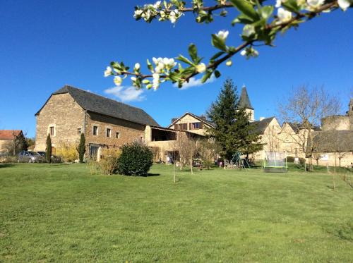 a large brick building with a grass field in front of it at LA GRANGE DU RIAL in Bournazel