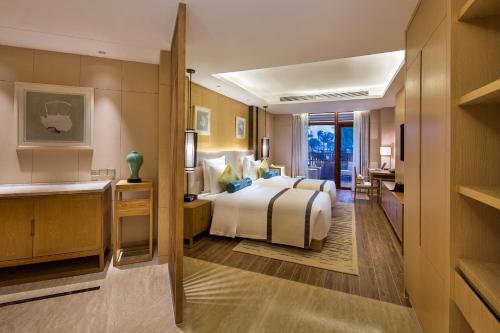 a hotel room with a bed and a desk at Wyndham Grand Plaza Royale Wenchang in Wenchang