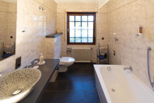 uma casa de banho com uma banheira, um WC e um lavatório. em Gästehaus Obsthof Gottenheim em Gottenheim