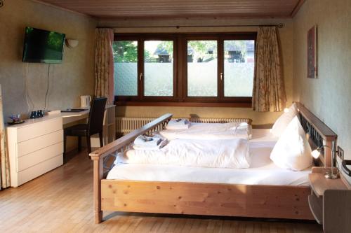 - une chambre avec un grand lit, un bureau et une fenêtre dans l'établissement Gästehaus Obsthof Gottenheim, à Gottenheim