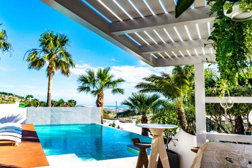 an outdoor patio with a swimming pool and palm trees at Diodorus Luxury Experience in Favara