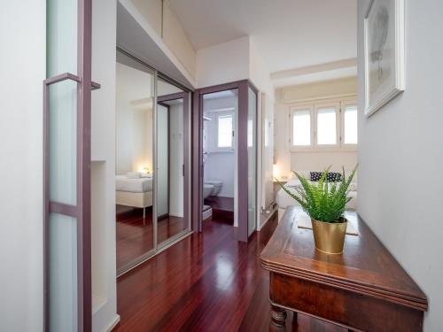 a hallway with a table and a mirror at Apartament Vigliani 19 in Milan