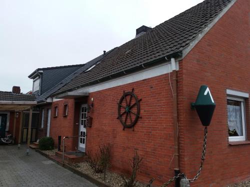 a red brick building with a peace sign on it at Pension Stürrad in Neuharlingersiel