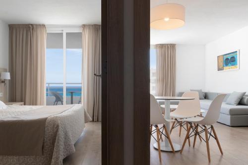 um quarto com uma cama, uma mesa e cadeiras em Hotel Palia Sa Coma Playa em Sa Coma