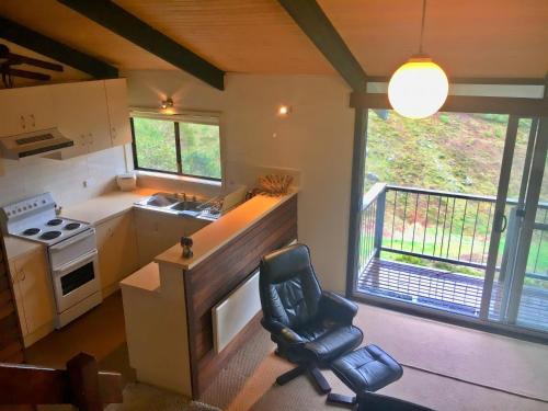 een keuken met een stoel in het midden van een kamer bij Katmandu 1 in Falls Creek