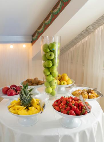 a table topped with bowls of fruit and plates of food at Hotel Milton Rimini in Rimini