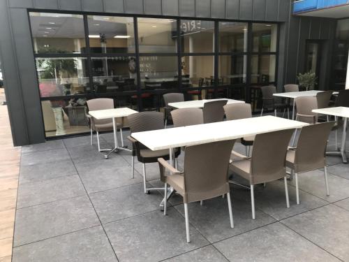 a row of tables and chairs in a restaurant at The Originals City, Hôtel Hélios, Roanne Nord in Mably