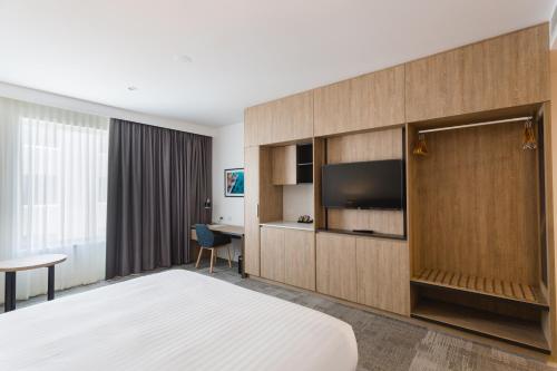 a hotel room with a bed and a television at Ingot Hotel Perth, Ascend Hotel Collection in Perth
