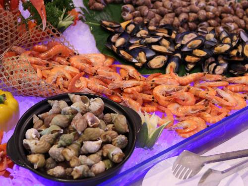 a table with a bunch of different types of food at Sanya Dadonghai Seaview Hotel in Sanya