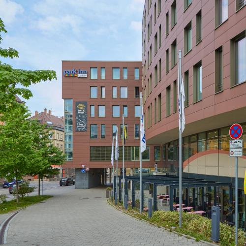 a building with flags in front of a street at Park Inn by Radisson Stuttgart in Stuttgart