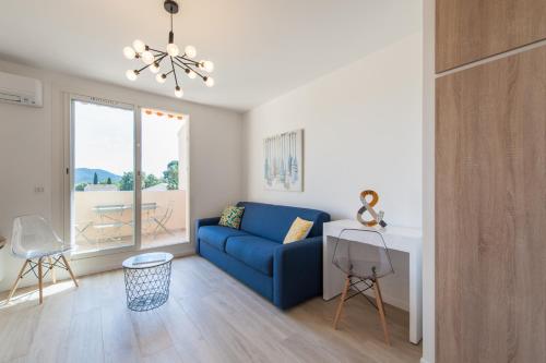 Una sala de estar con un sofá azul y una mesa. en Studio del Sol, en Saint-Cyr-sur-Mer