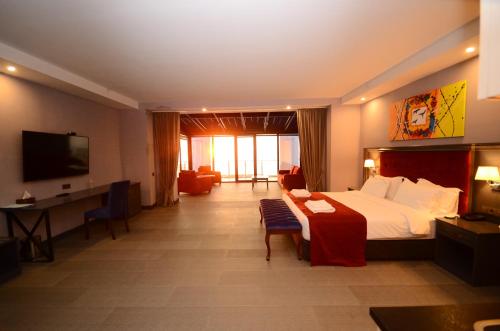 a hotel room with a bed and a desk and a television at Batumi Palm Hotel in Batumi