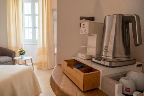 una camera d'albergo con una macchinetta del caffè su un tavolo di Corso Umberto Rooms a Olbia