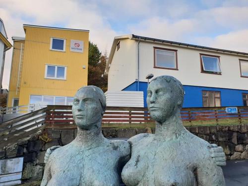 a statue of a man sitting on top of a building at 62N Guesthouse - City Center in Tórshavn