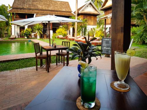 uma mesa com duas bebidas em cima em Villa Maydou Boutique Hotel em Luang Prabang