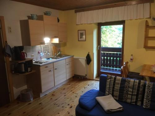 a living room with a blue couch and a kitchen at Appartement Georg in Unterburg am Klopeiner See