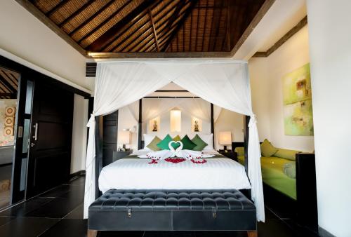 a bedroom with a large bed with a canopy at Villa Rumah Lotus in Payangan