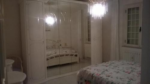 a white bedroom with a bed and a mirror at CASA ELEGANTE in Martinsicuro