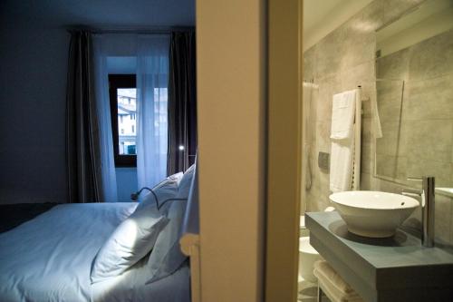 a bathroom with a bed and a sink in a room at Il Vecchio Borgo Relais in Como