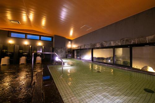 a swimming pool in a building with a swimming pool at Miyakonojo Green Hotel in Miyakonozyō