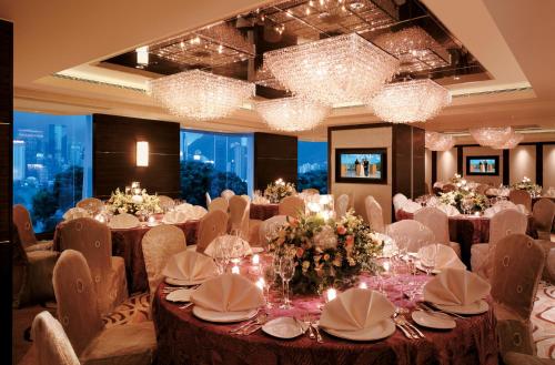 a banquet room with tables and chairs and chandeliers at Kowloon Shangri-La, Hong Kong in Hong Kong