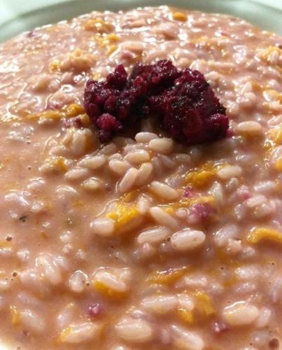 a bowl of oatmeal with a cranberry in it at Hotel Beau Sejour Pré-Saint-Didier in Pré-Saint-Didier