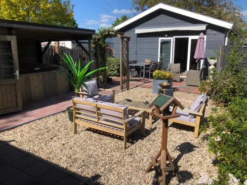 a patio with two chairs and a table in a yard at bungalow Onder de iep in Ermelo