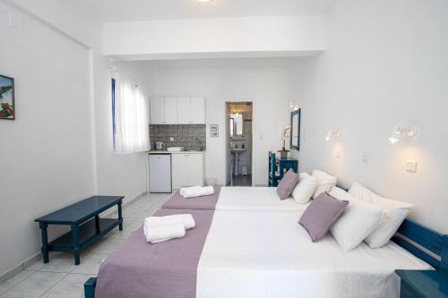a bedroom with a large white bed with purple pillows at Villa Happening in Imerovigli