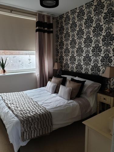 a bedroom with a large white bed with a window at The Beach Hut in Bridlington