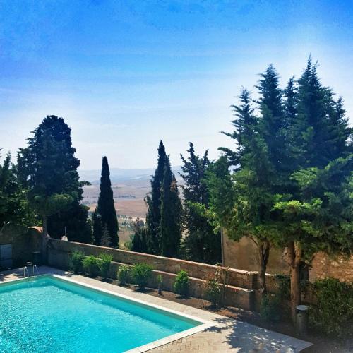 a swimming pool in a yard with trees at Relais Il Chiostro Di Pienza in Pienza