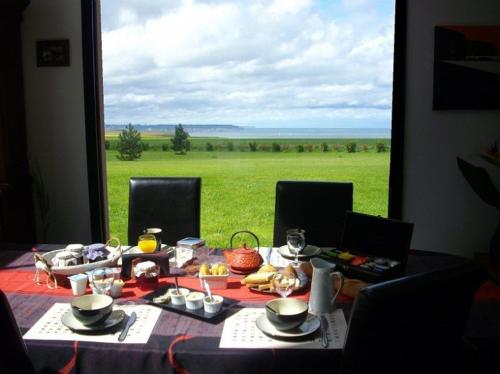 - une table à manger avec vue sur un champ dans l'établissement villa les falaises, à Berneval-le-Grand