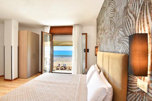 a bedroom with a bed and a view of the ocean at Hotel Excelsior in Caorle